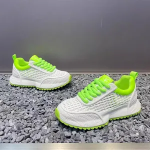Detailed view of white mesh sneakers with neon green accents and thick soles