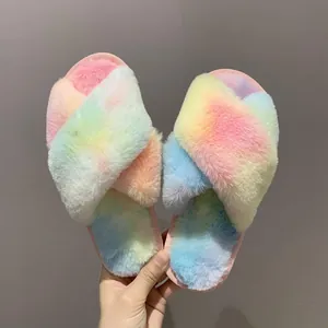 Detail view of colorful rainbow fuzzy slippers with a plush cross-strap design for indoor use