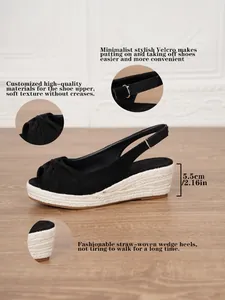 Detailed view of black wedge sandal with straw-woven platform and ankle strap