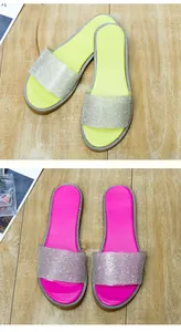 Gedetailleerd overzicht van modieuze platte sandalen met fonkelende strass in roze en geel