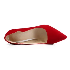 Vista detallada de elegantes tacones de aguja rojos con punta fina y acabado mate.