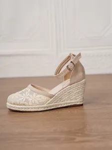 Vista detallada de alpargatas con cuña beige para mujer con elegantes bordados