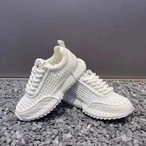 Detail view of white breathable mesh sneakers with chunky soles and textured woven finish.