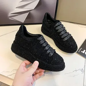 Detail shot of black women's rhinestone platform sneakers with glittery laces.