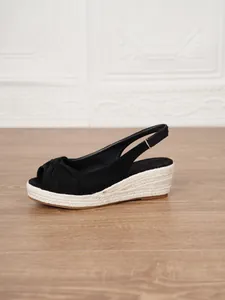 Side view detail of black suede peep-toe wedge sandals with espadrille rope sole