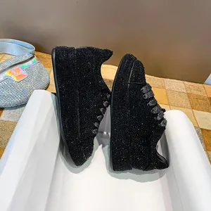 Detail view of women's black rhinestone platform sneakers with full crystal embellishment.