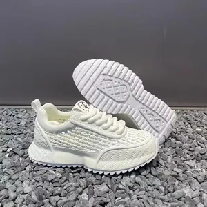 Close-up of white breathable mesh sneakers with textured sole and logo details