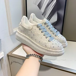 Detailed macro view of women's luxury rhinestone platform sneakers with blue laces