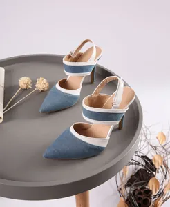 Detalle de sandalias de tacón de aguja en denim azul con ribetes blancos
