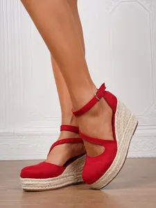 Detailansicht der roten Espadrilles-Keilsandaletten mit geflochtenem Plateau und Knöchelriemen.