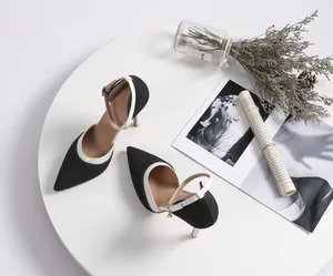 Detailed view of black denim slingback heels with white trim on a stylish setting
