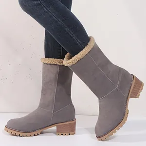 Close-up of grey mid-calf winter boots with warm faux fur lining and chunky heels