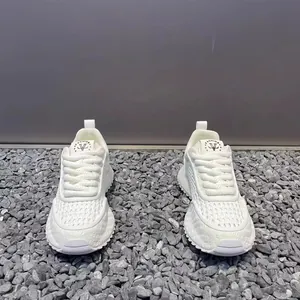 Detailed view of white breathable mesh sneakers for men on a grey stone background