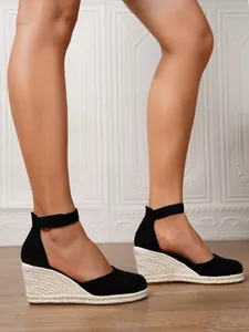 Vista detallada de sandalias de cuña de lona negra para mujer con suelas de alpargata
