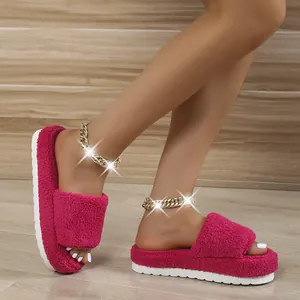 Detailed view of fuchsia faux fur slippers with thick platform soles and plush lining
