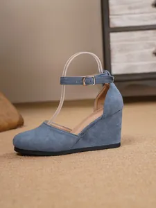 Seitenansicht der blauen Keilsandalette mit geschlossenem Zehenbereich und Metallschnalle