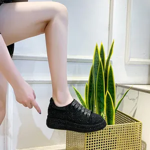 Close-up of black rhinestone platform sneakers showing full crystal texture and thick sole