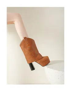 Vista detallada de botas de cuero marrón con plataforma, tacón de bloque y remaches.