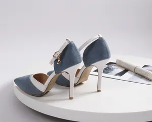 Detailed side view of blue denim pointed-toe stiletto heels with white ankle straps