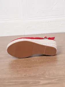 Gros plan sur la semelle en caoutchouc d'une sandale compensée rouge espadrille, taille 37