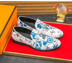 Detailed view of men's white loafers with blue floral print and elegant tassels.
