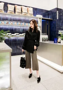 Elegant black pointed-toe mules with pearl embellishments worn by model in cafe