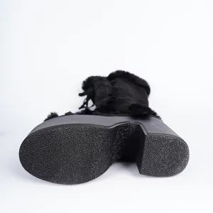 Detail view of black platform snow boots featuring a high heel and textured non-slip sole