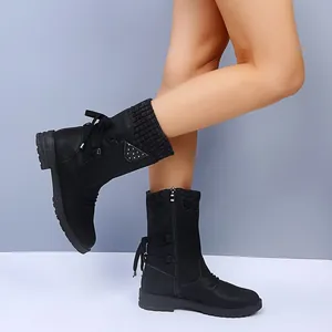 Side view of black mid-calf Martin boots featuring knitted cuffs and back bow detail
