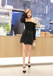 Elegantes tacones de aguja de punta blancos y negros mostrados en una modelo en un café