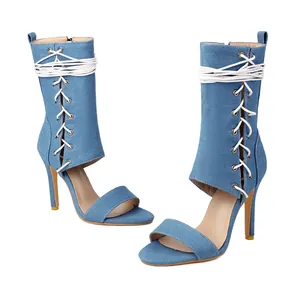 Détail de sandales à talons aiguilles en denim bleu clair avec laçage et découpes