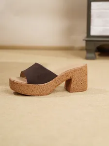 Detalle de un zueco marrón de ante con plataforma y suela con efecto de corcho