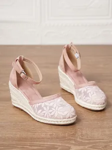 Primer plano de sandalias de cuña rosa con bordado floral y suelas de esparto tejidas