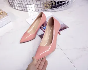 Detailed view of elegant glossy pink pointed-toe stiletto pumps with shiny patent leather finish