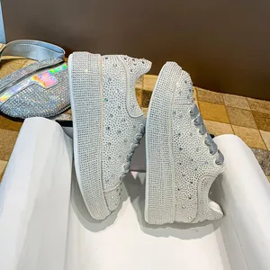 Detailed macro view of the sparkling rhinestones on white chunky platform sneakers
