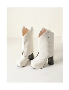 Primer plano de botines de cuero blanco con plataforma y tacones de bloque negros