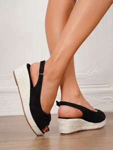 Detail of black platform wedge sandals with jute rope-wrapped sole and ankle strap.