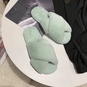 Detail view showing the soft texture of mint green cross-strap faux fur home slippers.