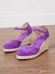 Dettaglio dei sandali con zeppa in espadrillas in pelle scamosciata viola
