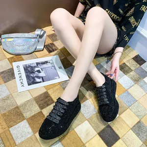 Detailed close-up of sparkling black rhinestone platform sneakers for women on a checkered rug