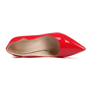 Vista superior de zapato de salón rojo de charol brillante con punta fina e interior beige