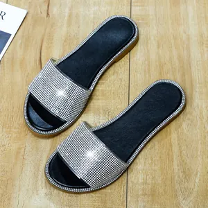 Gedetailleerd overzicht van platte dames strand slippers met glinsterende zilveren strass