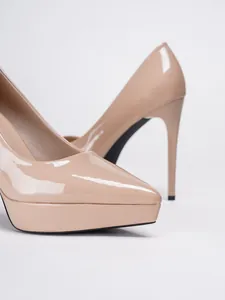 Close-up detail of nude patent leather pointed toe high heel with platform