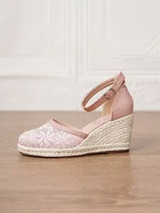 Vista lateral de sandalia de cuña rosa para mujer con bordado floral y correa al tobillo