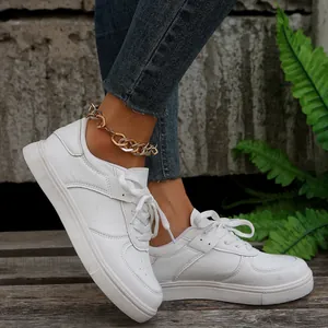 Seitenansicht der weißen Plattform-Sneaker mit Jeans und einem goldenen Fußkettchen