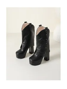 Vista detallada de botas negras de plataforma para mujer con tacón ancho y tachuelas.