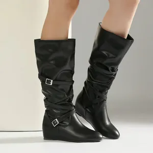 Detail view of black slouchy mid-calf boots with stylish buckle straps and pleats