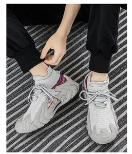 Side view of grey breathable knit sock sneakers with textured chunky soles worn outdoors
