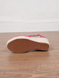 Detailansicht der braunen rutschfesten Gummisohle von fuchsia Espadrille-Keilsandalen.