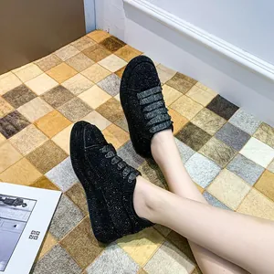 Detail shot of stylish black platform sneakers covered in sparkling rhinestones