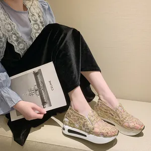 Close-up detail of stylish gold lace mesh platform sneakers with sparkly rhinestone accents